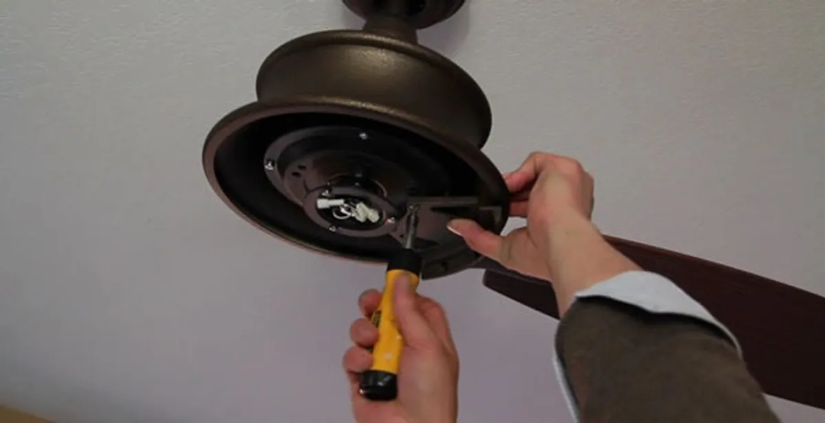 Electrician installing ceiling fan mounting bracket and fixture in Lancaster, PA